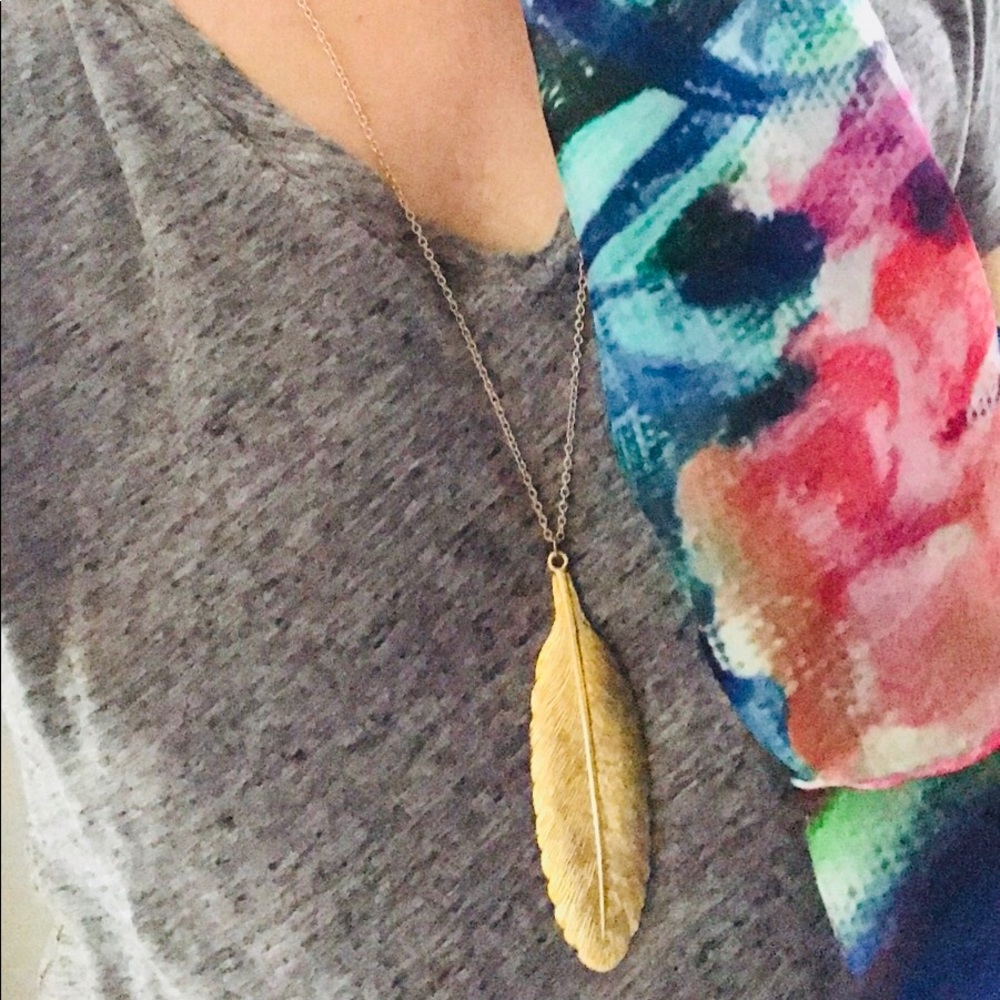 Gold long feather necklace.
